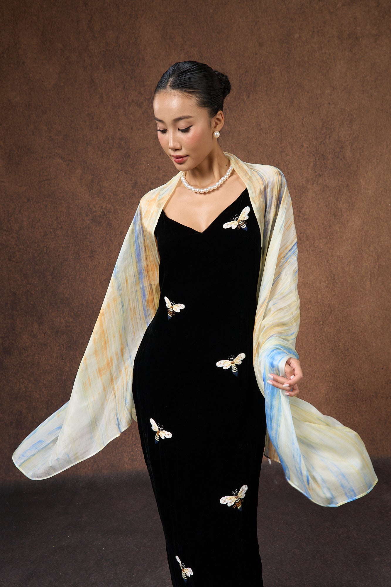 Close-up of the butter yellow and blue brushstroke silk scarf, showing hand-painted texture
