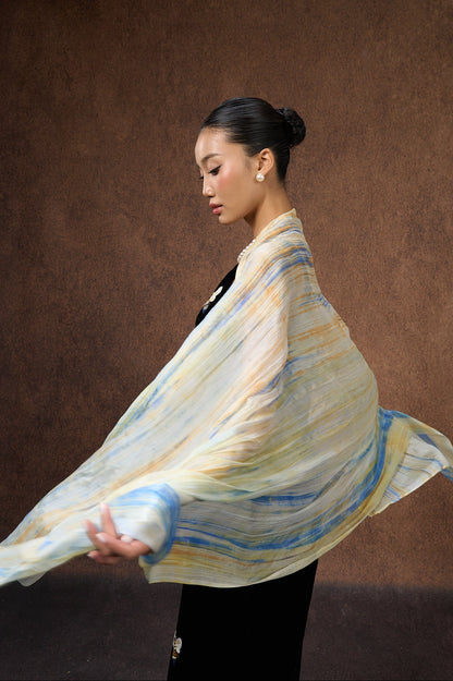 Back view of a model wearing the butter yellow and blue brushstroke silk shawl