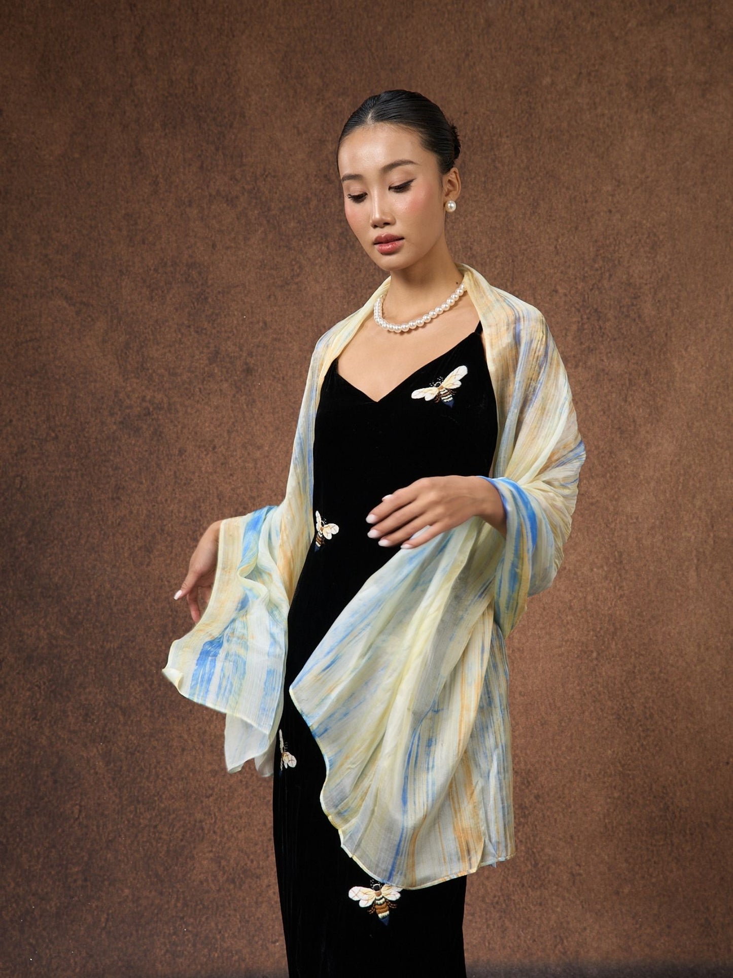 Butter yellow and blue brushstroke hand-dyed mulberry silk scarf, draped over the shoulders