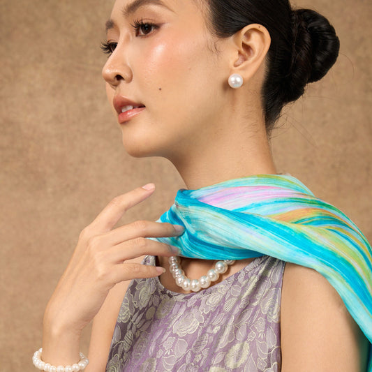 Model wearing pastel rainbow brushstroke hand-dyed silk scarf draped over shoulders — Silk & Bears
