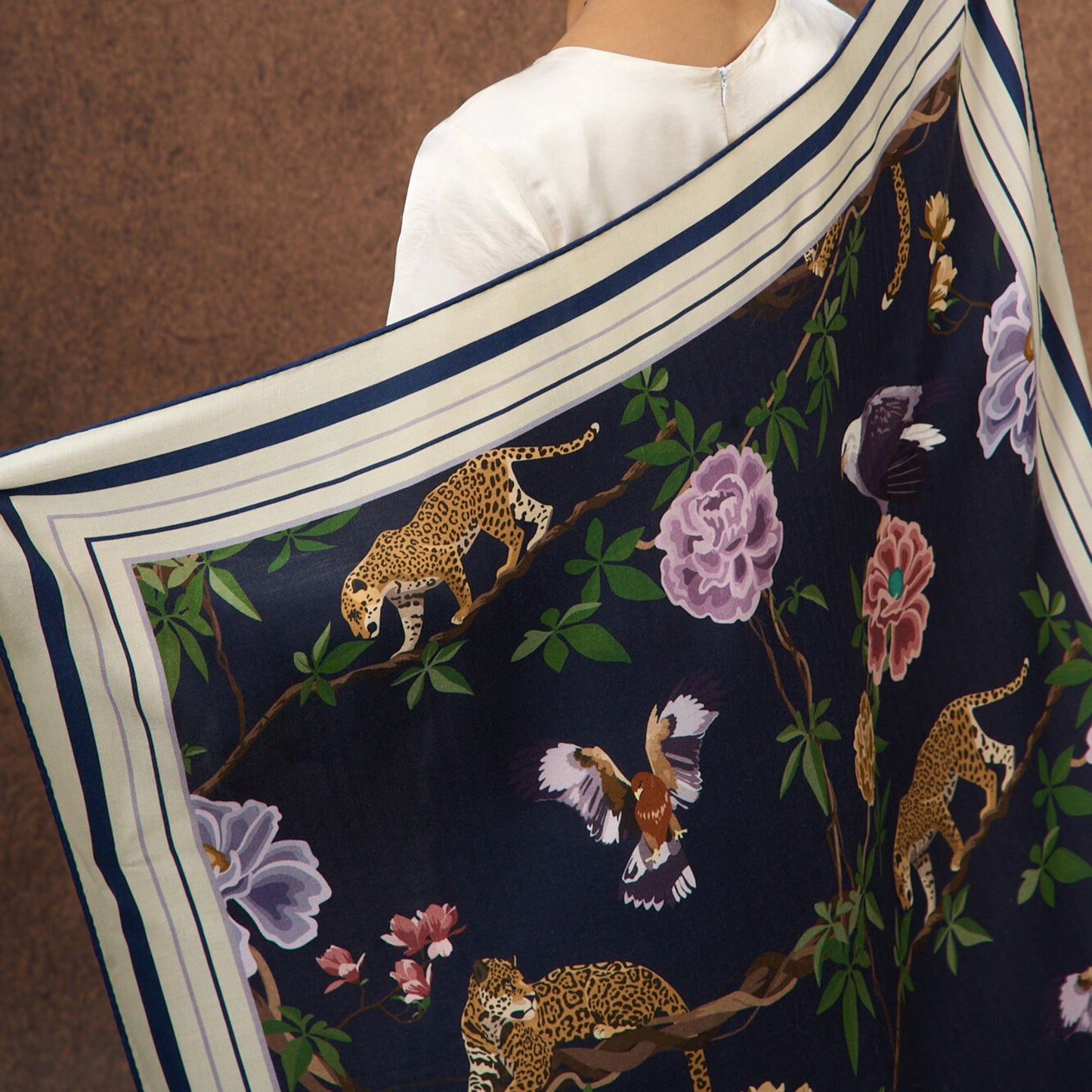 Midnight Safari wool-silk scarf styled around the neck, navy animal print