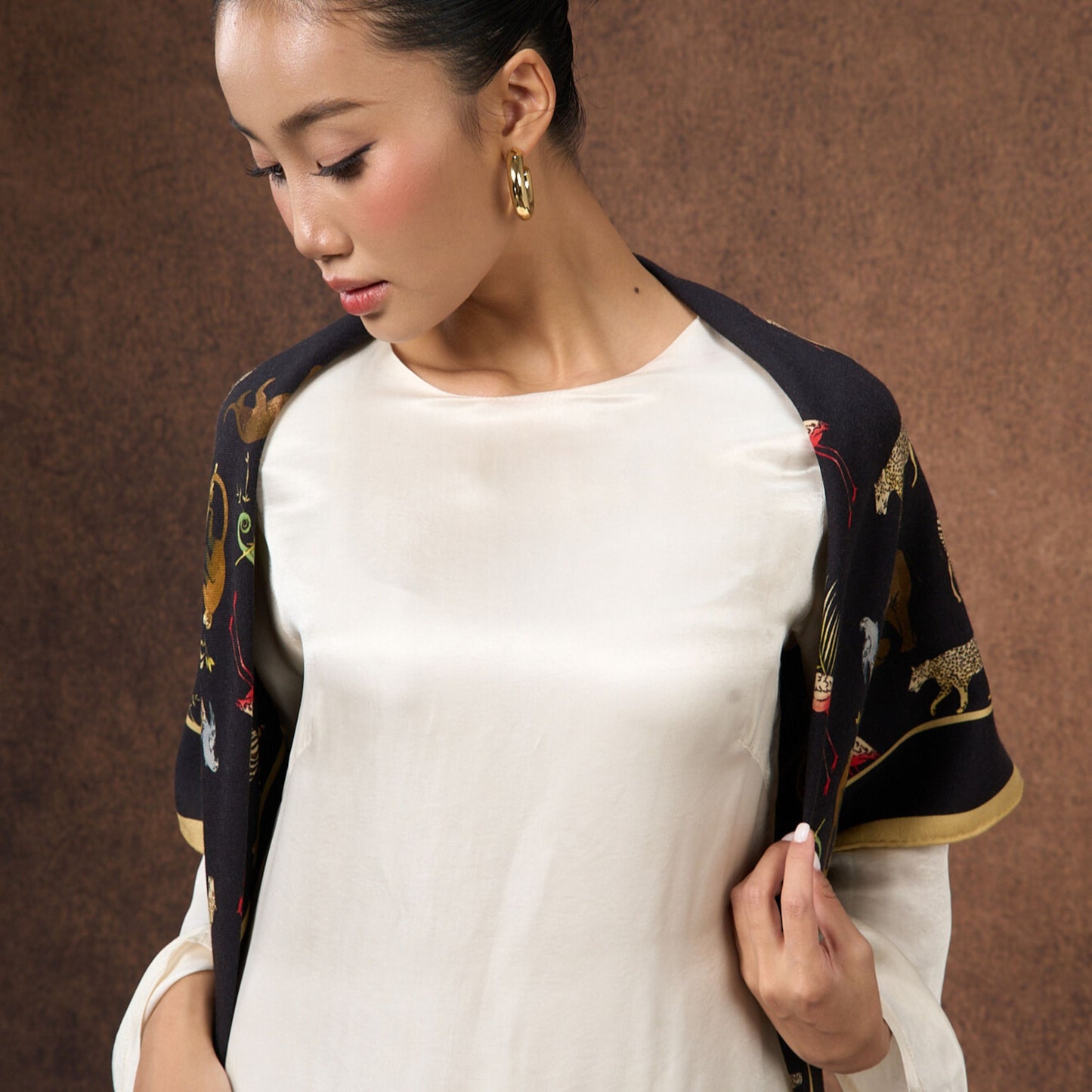 Model wearing the Noir Safari wool-silk scarf draped over the shoulders
