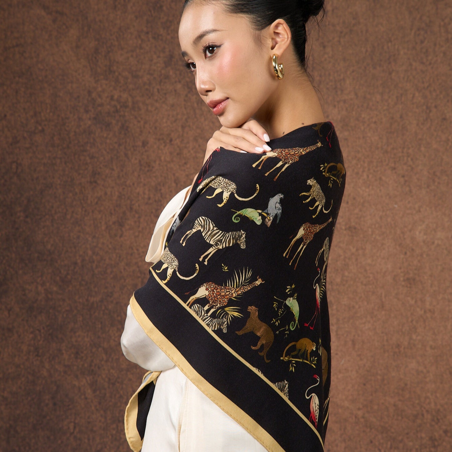 Close-up of the Noir Safari wool-silk scarf, showing the safari animal print