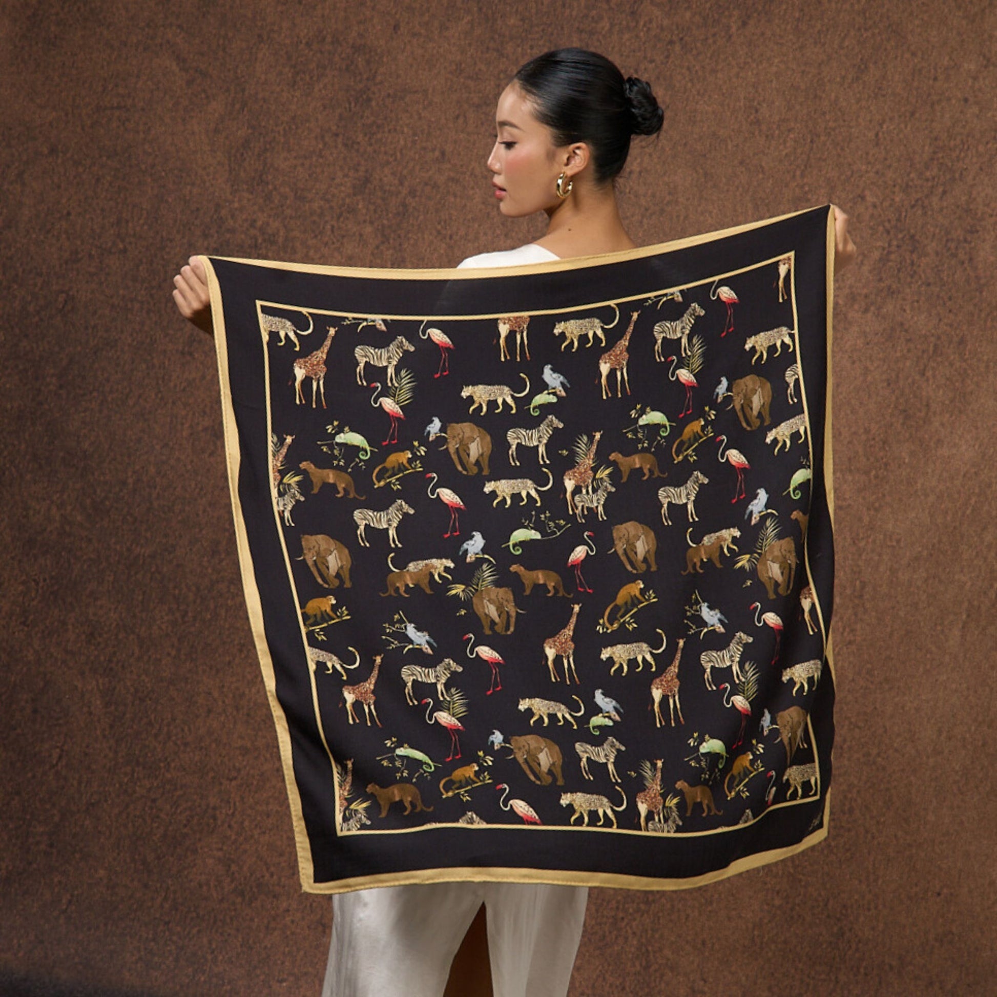 Back view of a model wearing the Noir Safari wool-silk scarf