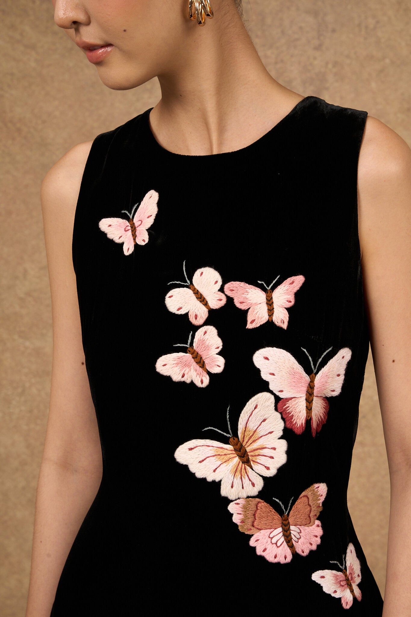 Close-up of the hand-embroidered butterfly motif on black silk velvet