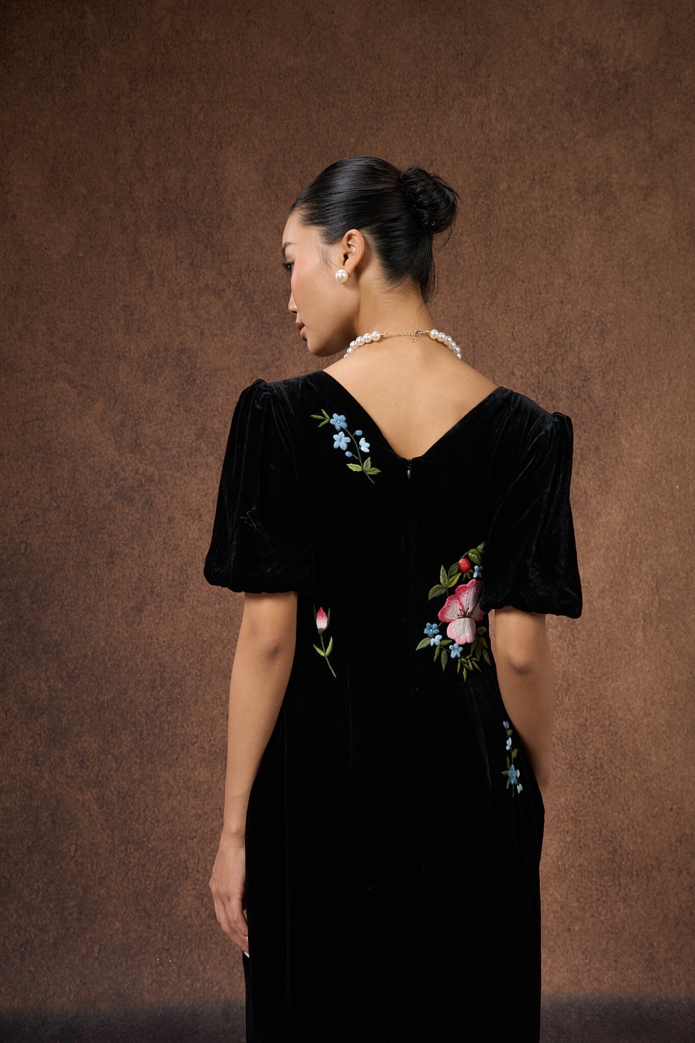 Back view of the hand-embroidered black floral silk velvet puff-sleeve dress