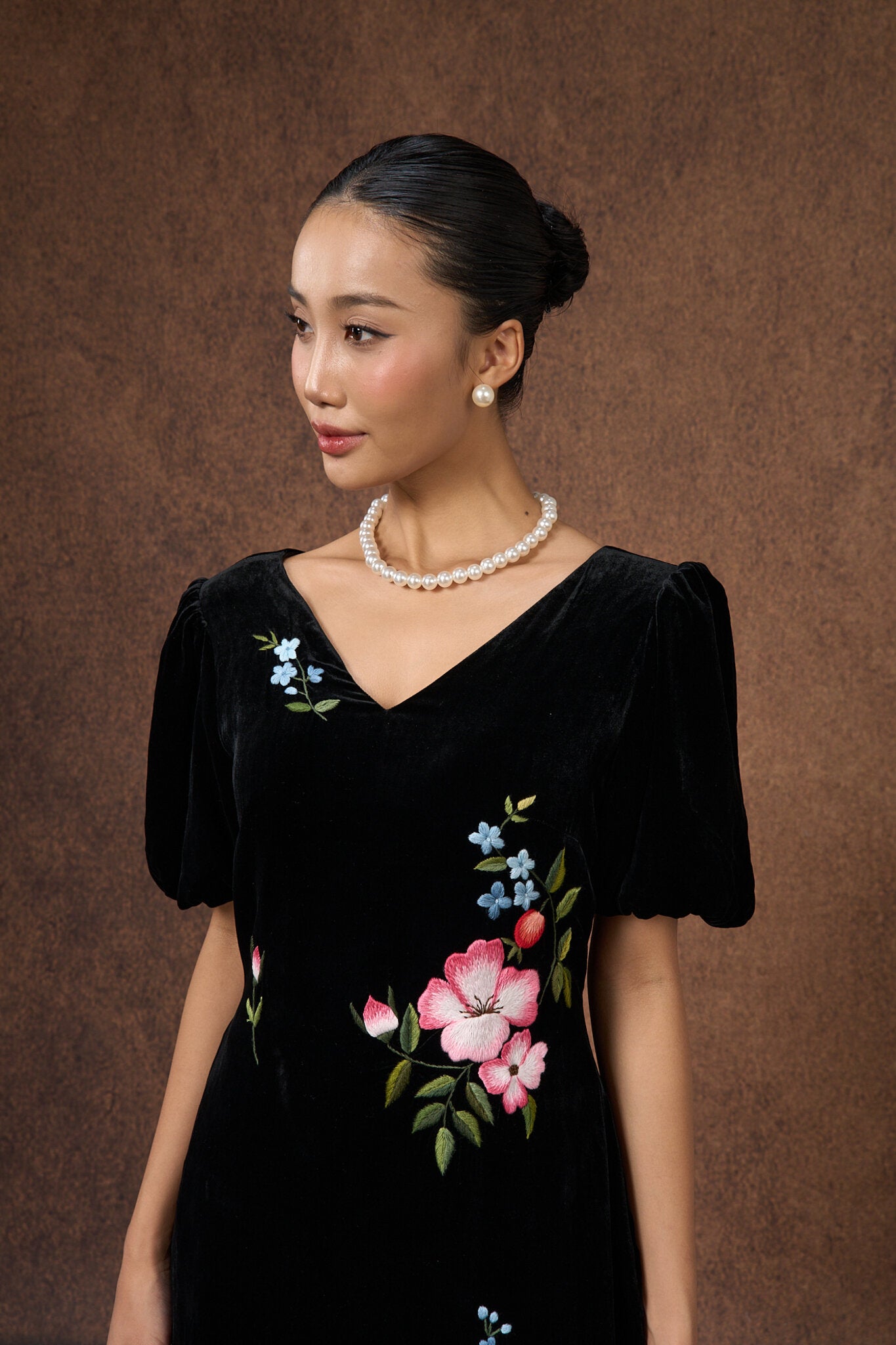 Side view of the hand-embroidered black floral silk velvet puff-sleeve dress