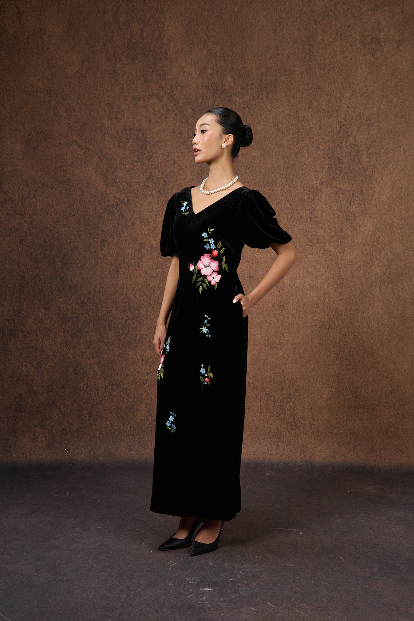 Close-up of the hand-embroidered floral motif on black silk velvet