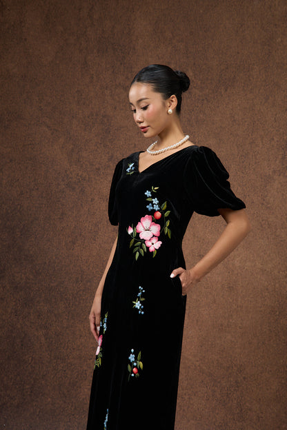 Model wearing the hand-embroidered black floral silk velvet puff-sleeve dress