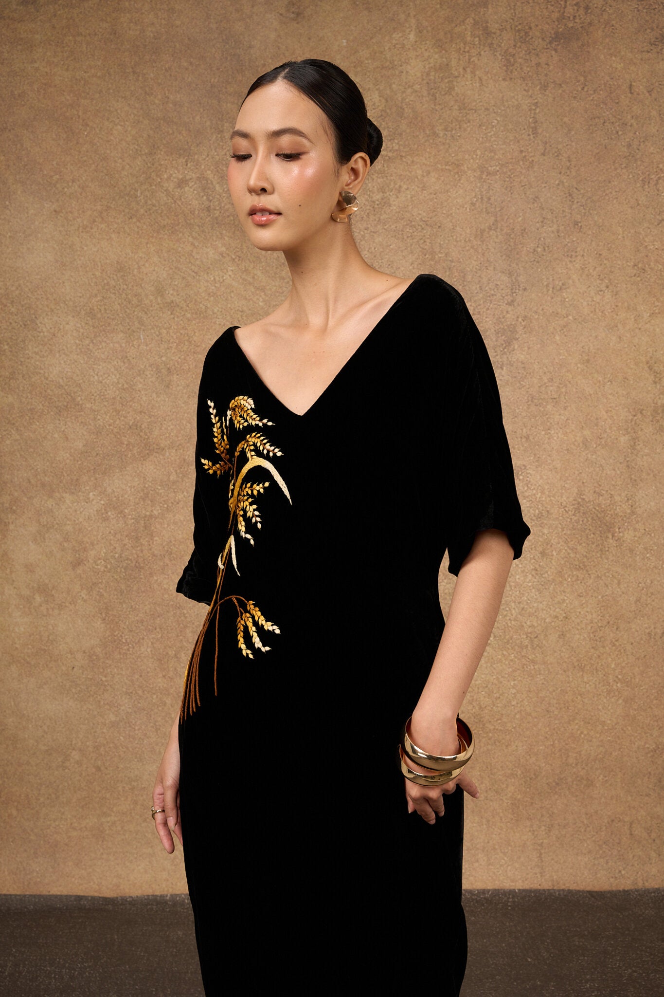 Side view of the hand-embroidered black and gold silk velvet kimono-sleeve dress