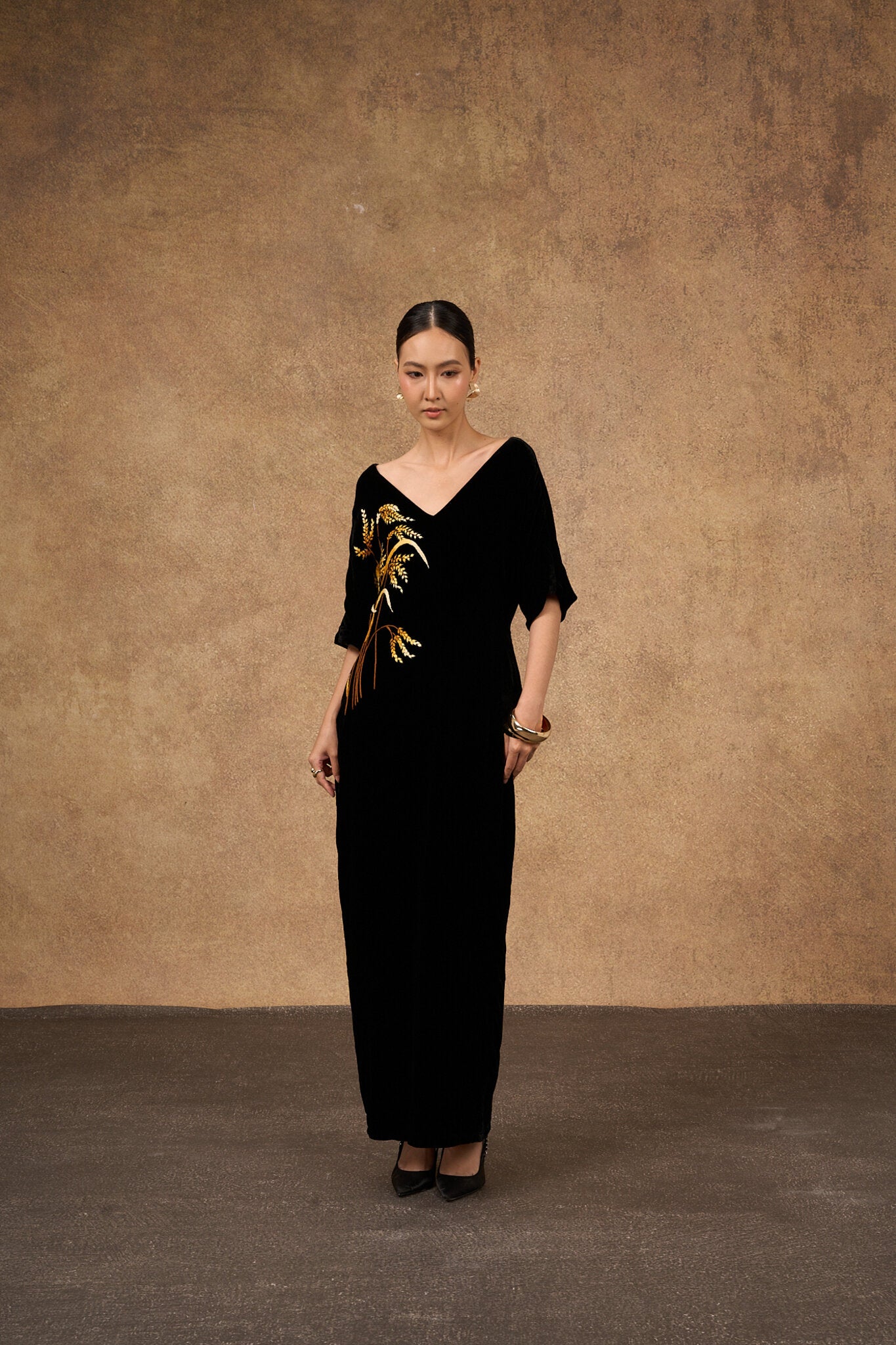 Editorial portrait of the hand-embroidered black and gold silk velvet dress