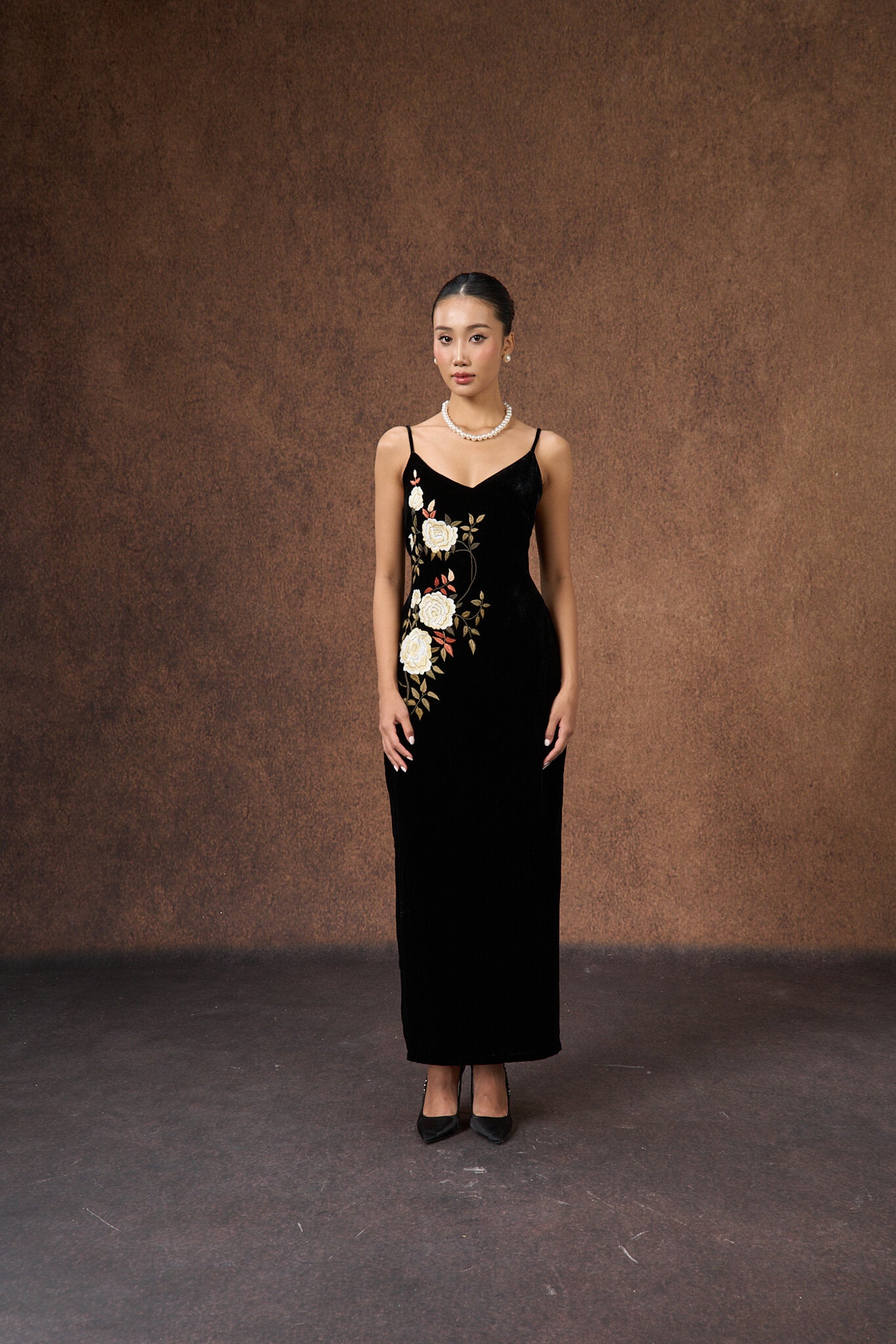 Close-up of the hand-embroidered rose motif on black silk velvet