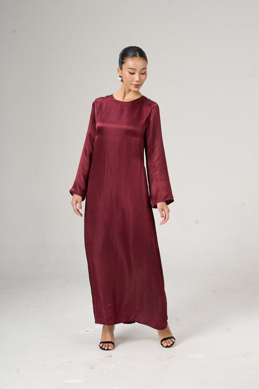 Woman wearing a burgundy dress on a white background
