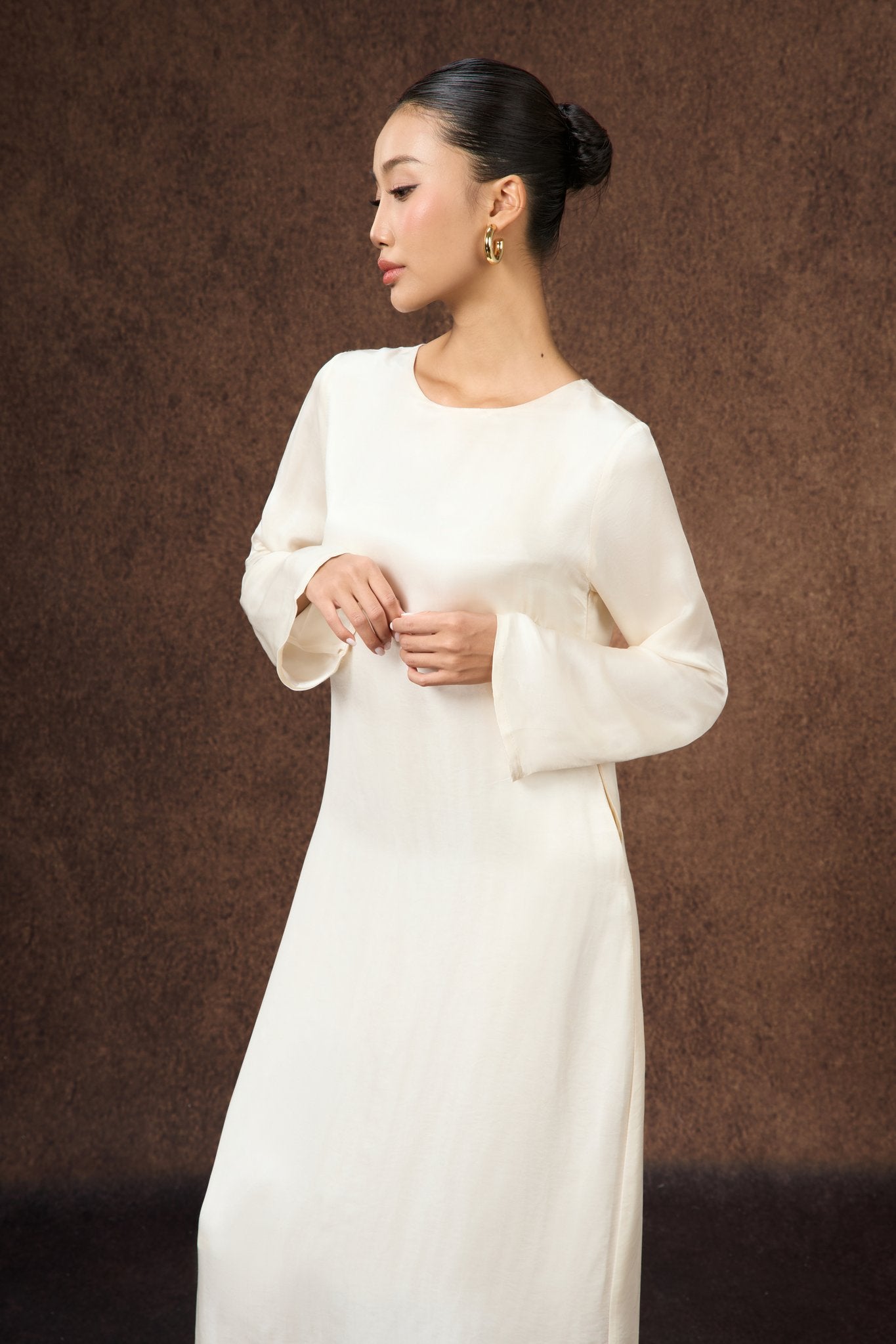 Model wearing the Celeste ivory pearl silk maxi dress, three-quarter view