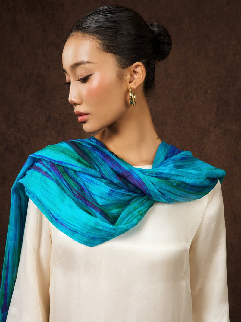 Model wearing teal blue hand-dyed striped silk shawl